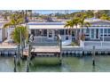 Waterfront home featuring a private dock, lush landscaping, and serene water views, perfect for relaxation at 19 Seaside Ct, Holmes Beach, FL 34217