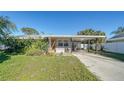 Updated Florida bungalow features a carport and a lush lawn at 2111 Outer Dr, Sarasota, FL 34231