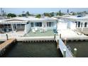 Waterfront home featuring a private dock, patio, and charming exterior details, perfect for coastal living at 23 Seaside Ct, Holmes Beach, FL 34217