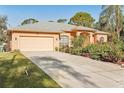 Charming single-story home featuring a neutral color palette, well-manicured landscaping, and an attached two-car garage at 3623 Monday Ter, North Port, FL 34286