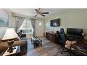 Living room with gray couch, wood-look floors, and a large TV at 3704 35Th W St, Bradenton, FL 34205