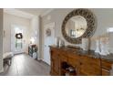 Entryway with wood console table, large round mirror, and tile flooring at 10233 Loch Lomond Dr, Bradenton, FL 34211