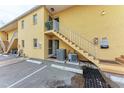 Rear view showing building entrance, stairs, and AC units at 115 Tyler Dr # 203, Sarasota, FL 34236