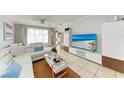 Living room features white sectional sofa and large TV at 115 Tyler Dr # 203, Sarasota, FL 34236