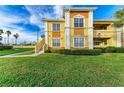 Two story yellow building with stairs and landscaping at 1195 Villagio Cir # 201, Sarasota, FL 34237