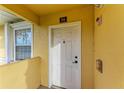 White front door with welcome mat and yellow building exterior at 1195 Villagio Cir # 201, Sarasota, FL 34237