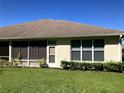 Rear view of house with screened porch, windows, and lawn at 2544 Cottonwood Ln, North Port, FL 34289