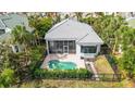 Home features a pool, screened lanai, and lush landscaping in backyard at 3607 Fair Oaks Pl, Longboat Key, FL 34228