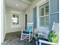 Front porch with rocking chairs, entryway, and windows with shutters at 3028 Sky Blue Cv, Bradenton, FL 34211