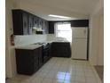 Cozy kitchen with dark wood cabinets and white appliances at 3245 Roxbury Dr, Holiday, FL 34691