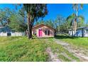 Tan house with pink door and large tree in front yard at 5120 17Th Street E Ct, Bradenton, FL 34203