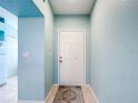 Light blue entryway with a white door and small rug at 5725 Greenwood Ave # 6203, North Port, FL 34287