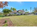 White house with tropical landscaping and a large grassy yard at 7003 River Club Blvd, Bradenton, FL 34202