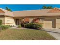 Tan house with orange shutters, a well-manicured lawn, and a paved driveway at 3607 57Th Avenue W Dr, Bradenton, FL 34210