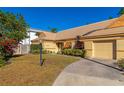 Tan house with orange shutters, a well-manicured lawn, and a paved driveway at 3607 57Th Avenue W Dr, Bradenton, FL 34210