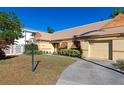 Tan house with orange shutters, a well-manicured lawn, and a paved driveway at 3607 57Th Avenue W Dr, Bradenton, FL 34210