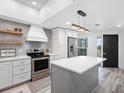 Bright kitchen with stainless steel appliances, center island, modern lighting, and gray backsplash at 4204 126Th W St # 506, Cortez, FL 34215