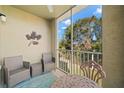 Screened balcony with wicker chairs and a metal table at 5601 Bentgrass Dr # 10-112, Sarasota, FL 34235