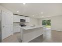 Modern kitchen with white cabinets, marble countertops, and stainless steel appliances at 5829 Flagstone Trl, Palmetto, FL 34221