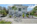 Two story home with gray siding, metal roof, and landscaped yard at 7418 Westmoreland Dr, Sarasota, FL 34243