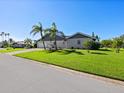 Gray house with metal roof, landscaping, and two palm trees at 120 Lookout Point Dr, Osprey, FL 34229