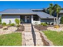 Gray house with metal roof, landscaping, and a walkway at 120 Lookout Point Dr, Osprey, FL 34229
