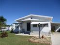 Front view of a white single-wide manufactured home with carport at 1208 44Th Avenue E Dr, Ellenton, FL 34222
