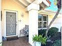 Inviting front entry with secure storm door, tiled porch, and charming decorative details at 148 Inlets Blvd # 148, Nokomis, FL 34275