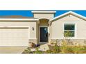 Home's entrance, showcasing a black door and stone accents at 15813 6Th E Ave, Bradenton, FL 34212