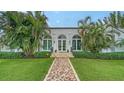 Elegant home featuring a mosaic walkway, arched windows, and lush green lawn at 1682 Hawthorne St, Sarasota, FL 34239