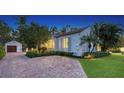 Exterior view of a charming home with a brick driveway and lush landscaping at 1682 Hawthorne St, Sarasota, FL 34239