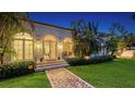 Home exterior with a mosaic walkway, arched windows, and a lush green lawn at 1682 Hawthorne St, Sarasota, FL 34239
