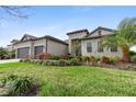 Landscaped front yard of this beautiful gray home with a three-car garage at 4906 Lighthouse Bay Ln, Bradenton, FL 34211
