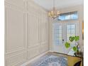 Elegant foyer with wainscoting, a decorative chandelier, and a patterned area rug at 4906 Lighthouse Bay Ln, Bradenton, FL 34211