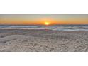 Beautiful beach with soft sand and gentle waves at sunset, creating a serene and picturesque scene at 681 Casey Key Rd, Nokomis, FL 34275