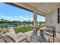 Covered patio overlooking a canal, furnished with wicker seating and outdoor rug at 1173 Rotonda Cir, Rotonda West, FL 33947