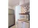 Retro kitchen with light wood cabinets, microwave, and refrigerator at 2228 Canal Dr # D26, Bradenton, FL 34207