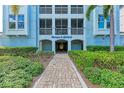 Welcoming building entrance with a brick pathway, lush landscaping, and the building name displayed prominently at 396 Aruba Cir # 103, Bradenton, FL 34209