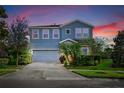 Two-story house with blue exterior, gray garage door, and landscaping at 6138 Colmar Pl, Apollo Beach, FL 33572