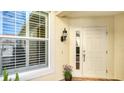 Front entry with white door, window with shutters, and potted plant at 1257 Burgos Dr # 302, Sarasota, FL 34238