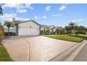 Front view of a single-story house with a driveway and landscaping at 4028 Dover E Dr, Bradenton, FL 34203