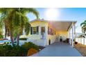 Bright yellow home with covered carport and landscaping at 5037 Oakland Hills Ave, Sarasota, FL 34234