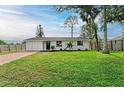Front yard view of a charming house with a well-manicured lawn at 875 Royal Rd, Venice, FL 34293