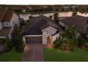 Aerial view of single-Gathering home with tile roof, paver driveway, mature trees, and water view at 12232 Perennial Pl, Lakewood Ranch, FL 34211