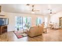 Bright living room with wood floors, a ceiling fan and sliding glass doors leading to the pool area at 1496 Palm View Rd, Sarasota, FL 34240