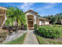 Inviting front entrance with double doors and lush landscaping at 15903 Armistead Ln, Odessa, FL 33556