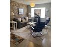 Living room with stone wall, gray sofa, and coffee table at 1680 17Th St, Sarasota, FL 34234
