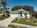 Single-story house with tile roof and attached garage, nicely landscaped at 2316 Harrier Way, Nokomis, FL 34275