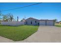 View of the home's rear exterior showing a spacious backyard and a detached two-car garage at 2401 15Th W St, Palmetto, FL 34221