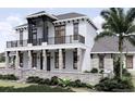 Two-story home with gray roof, white siding, stone accents, and a balcony at 32206 Grand National Drive, Myakka City, FL 34251